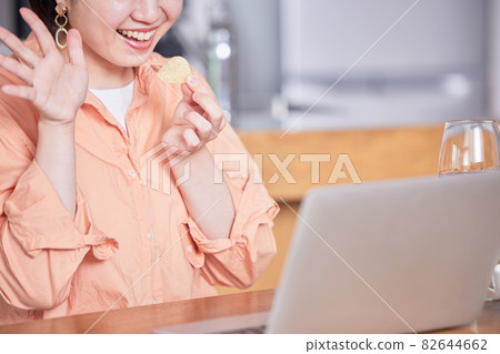 Young woman enjoying an online drinking party Young woman enjoying an online drinking party 82644662