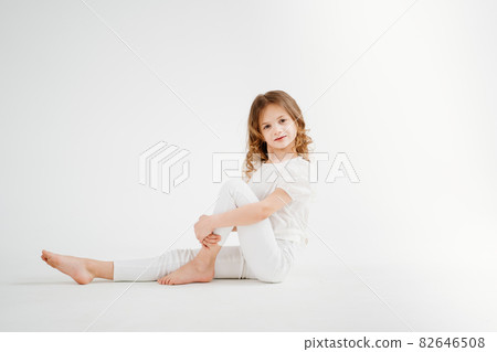 barefoot little girl with long hair in white clothes.shampoo for children's hair 82646508