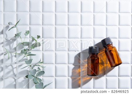 Two bottles of aroma oil and eucalyptus leaves. There is copy space. 82646925