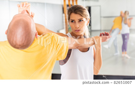 Woman performing palm heel strike while training in gym Woman performing palm heel strike while training in gym 82651007