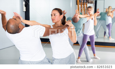 Hispanic girl using palm to launch blow in chin during self defence training Hispanic girl using palm to launch blow in chin during self defence training 82651023
