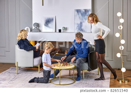 Grandfather plays chess with grandson during family evening. Grandfather plays chess with grandson during family evening. 82651540