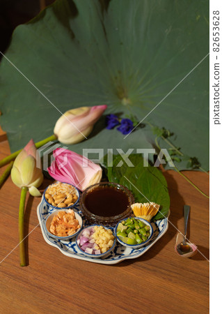 A set of Miang kham, Thai appetizer food with Lotus flower and leaf wrapped on traditional ceramic serving dish. 82653628