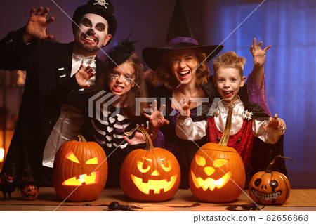 Young family mother father and children in Halloween costumes celebrating all hallows eve at home Young family mother father and children in Halloween costumes celebrating all hallows eve at home 82656868