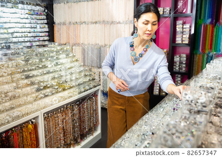 Asian female shopper looking for costume jewelry in showroom Asian female shopper looking for costume jewelry in showroom 82657347