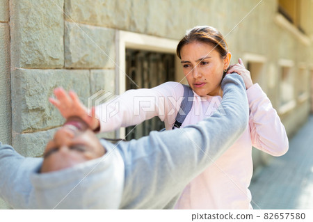 Strong woman using forceful blow in the eyes of rapist on street Strong woman using forceful blow in the eyes of rapist on street 82657580