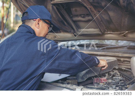 Mechanic car service auto garage in automotive mobile center. Technician workshop repair engine motor vehicles service mechanical engineering business. Automobile mechanic hands car repairs technic Mechanic car service auto garage in automotive mobile center. Technician workshop repair engine motor vehicles service mechanical engineering business. Automobile mechanic hands car repairs technic 82659383