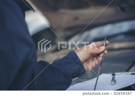 Car Mechanic man hand checking dipstick engine oil car mechanical on site service. Close up hand man check engine oil level Locate dipstick, wipe clean, check dipstick level before fill up engine oil Car Mechanic man hand checking dipstick engine oil car mechanical on site service. Close up hand man check engine oil level Locate dipstick, wipe clean, check dipstick level before fill up engine oil 82659387