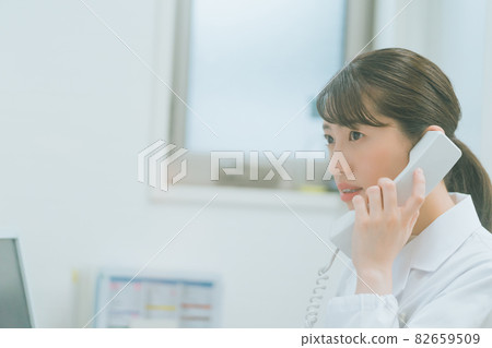 Telephone scene of a woman in a white coat Telephone scene of a woman in a white coat 82659509