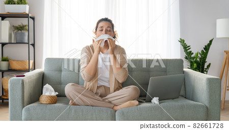 girl is holding paper tissue and blowing nose girl is holding paper tissue and blowing nose 82661728