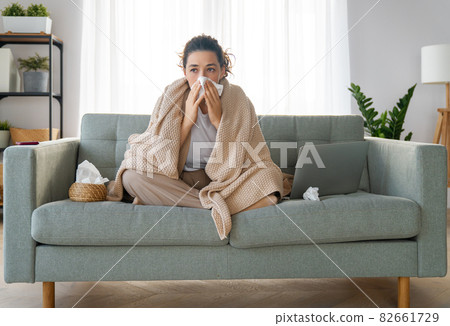 girl is holding paper tissue and blowing nose girl is holding paper tissue and blowing nose 82661729