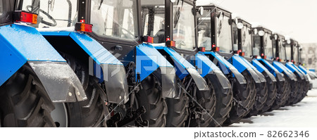 Many different tractors standing in row at agricultural fair for sale outdoors.Equipment for agriculture.Heavy industrial machines presented to agricultural exhibition. Agribusiness leasing concept 82662346