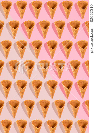 Sugar waffle cone for ice cream arranged in pattern on pink background. The image with copy space can be used as a background for the design of the confectionery menu Sugar waffle cone for ice cream arranged in pattern on pink background. The image with copy space can be used as a background for the design of the confectionery menu 82662510