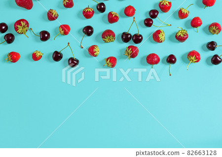 Fresh cherries and strawberries on mint background, top view 82663128