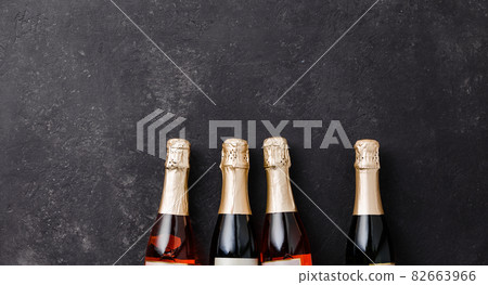 Four champagne bottles on dark background, flat lay 82663966