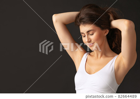 Half-length portrait of young beautiful slim woman in white lingerie, bra and panties isolated over dark background. Natural beauty concept. Half-length portrait of young beautiful slim woman in white lingerie, bra and panties isolated over dark background. Natural beauty concept. 82664489