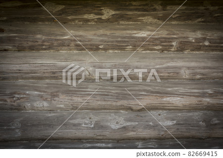 Wooden logs of an old house. Close-up. Weathered natural gray wood texture. Background. Horizontal photo 82669415