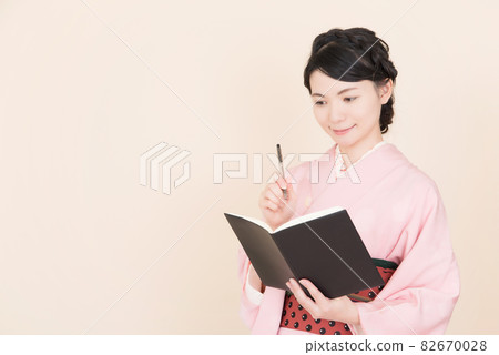 Woman in kimono with notebook 82670028