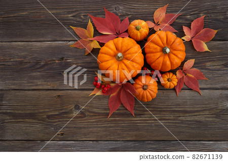 Framework with pumpkins and fall leaves on wooden background. Top view. 82671139