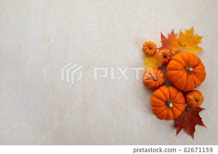 Autumn framework from pumpkins, berries and leaves on a travertine background. Concept of Thanksgiving day or Halloween. Autumn framework from pumpkins, berries and leaves on a travertine background. Concept of Thanksgiving day or Halloween. 82671159