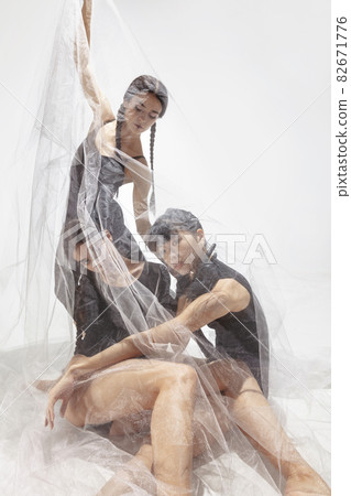 Modern ballet performance. Group of modern dancers at art contemp dance, Tree ballerinas under transparent voile fabric 82671776