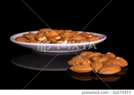 Fresh almond on black glass 82673453