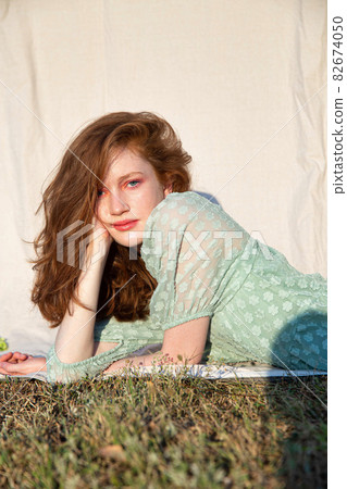 Girl with bright makeup on grass 82674050