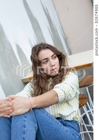 Girl with dark hair near the wall 82674988