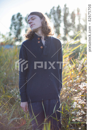 Man with long hair with trees behind 82675708