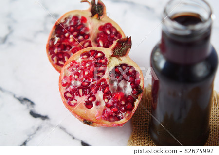 glass on pomegranate juice on red background . glass on pomegranate juice on red background . 82675992
