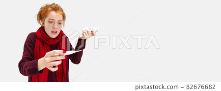 Cropped portrait of young Caucasian girl looking at electronic thermometer and having high temperature isolated over white background 82676682