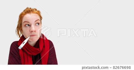 Cropped portrait of young Caucasian girl feeling sick and measuring temperature with electronic thermometer isolated over white background 82676698