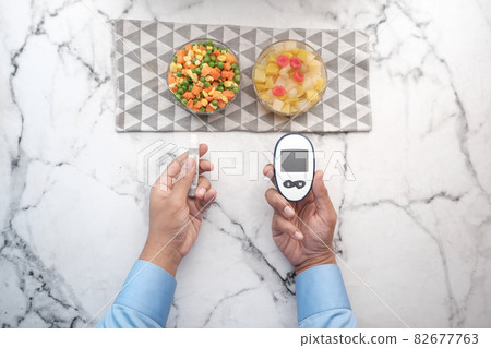 man's hand measuring blood sugar level  82677763