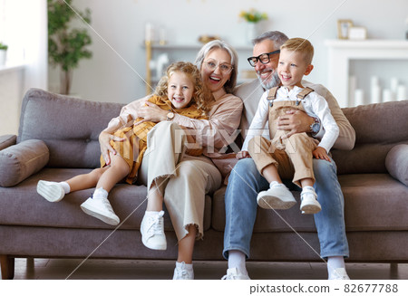 Happy family joyful little children hugging embracing with positive senior grandparents at home Happy family joyful little children hugging embracing with positive senior grandparents at home 82677788