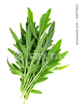 Arugula leaves isolated on white background. Closeup fresh wild rocket leaves on white background top view. 82678422