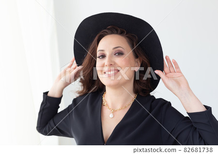 Portrait of a beautiful graceful woman in elegant hat with a wide brim. Beauty and fashion concept. Portrait of a beautiful graceful woman in elegant hat with a wide brim. Beauty and fashion concept. 82681738