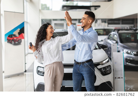 Emotional middle-eastern lovers giving high five, buying new auto Emotional middle-eastern lovers giving high five, buying new auto 82681762