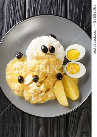 traditional peruvian food recipe with chicken meat and pepper sauce in the plate. Vertical top view 82682365