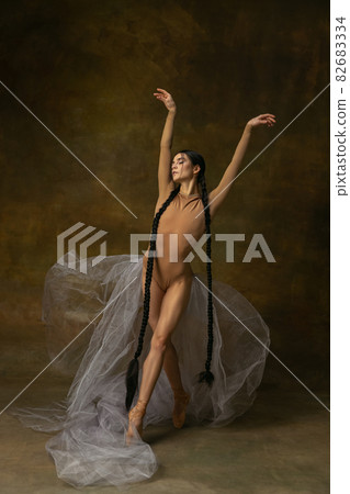 Full-length portrait of young, beautiful ballerina posing isolated over studio background 82683334