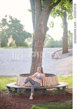 A mid aged woman in sportswear resting after the workout A mid aged woman in sportswear resting after the workout 82685838
