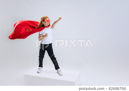 Portrait of little Caucasian girl, child posing isolated over white studio background. Little superhero. Flyer Portrait of little Caucasian girl, child posing isolated over white studio background. Little superhero. Flyer 82686708