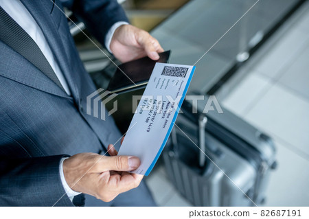 Man considering plane ticket at airport Man considering plane ticket at airport 82687191