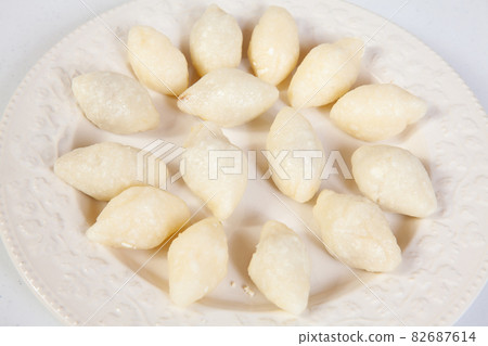 Preparation of a traditional Colombian fried  stuffed yucca dumplings called carimanolas 82687614