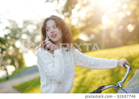 A young girl in a park with a smartphone in hands 82687746