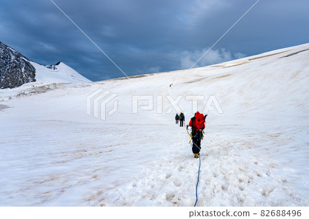 Group of mountaineers on a rope. Summer glacier trekking on Grossvenediger Mountain, Hohe Tauern National Park, Austrian Alps Group of mountaineers on a rope. Summer glacier trekking on Grossvenediger Mountain, Hohe Tauern National Park, Austrian Alps 82688496