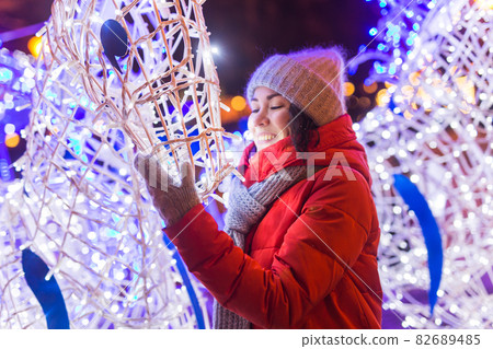Young pretty funny girl having fun outdoor in winter. Christmas, city and winter holidays concept. 82689485