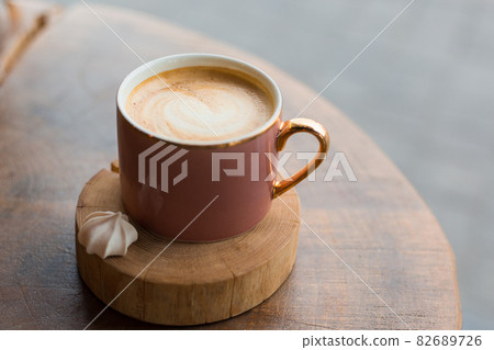 One Cup of cappuccino with latte art. Coffee in pink cup on old wooden table in cafe. Concept of easy breakfast. 82689726