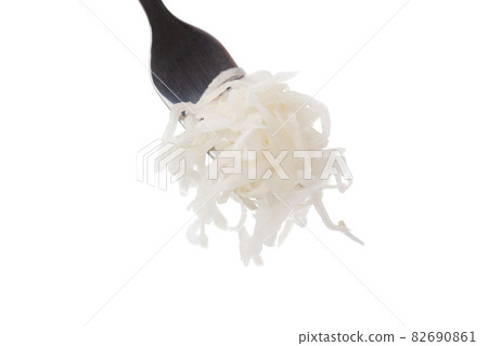Sauerkraut on a white background. Pickled cabbage close-up in a fork on a white background. Sauerkraut on a white background. Pickled cabbage close-up in a fork on a white background. 82690861