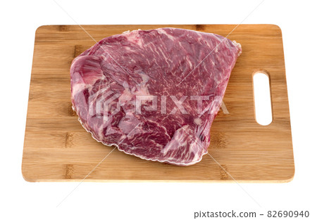 Vacuum packed meat on a white background. Beef in a vacuum bag on a board close-up. 82690940
