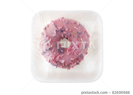 Donut close-up on a white background. Round donut in packaging close-up. Donut close-up on a white background. Round donut in packaging close-up. 82690986